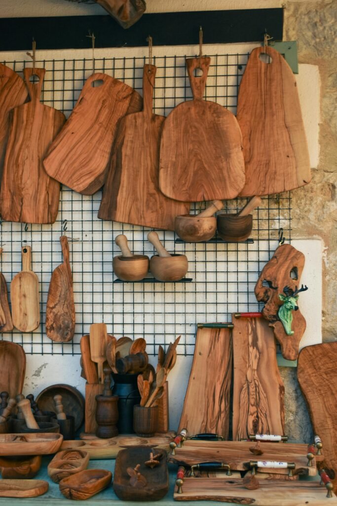 A variety of handcrafted wooden kitchen tools and boards on display in a shop.