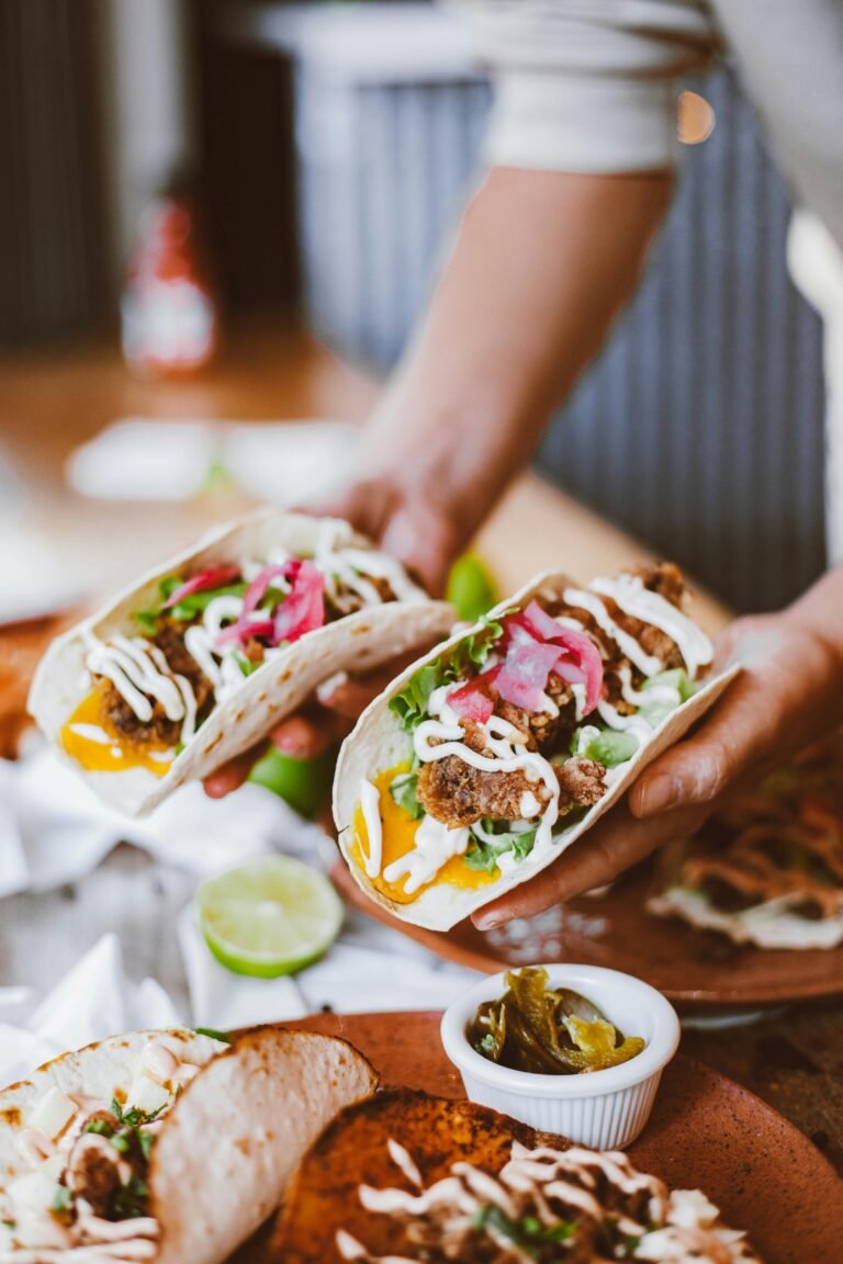 Freshly prepared beef tacos with toppings being served, perfect for food enthusiasts.